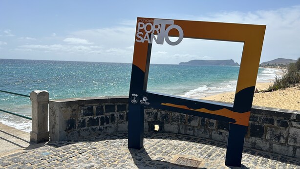 Une vue sur la côte, avec un panneau indiquant « Porto Santo » et un mur de pierres.