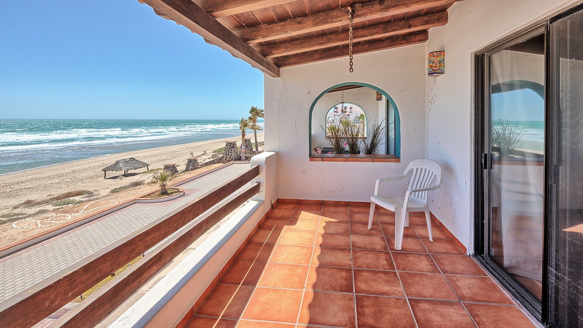 Un balcon avec vue sur la plage et l’océan.