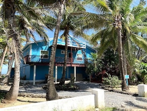 Situated among palm trees, this two-story building features a balcony on the upper floor.