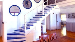 A modern interior with a staircase, white walls, and blue accents.