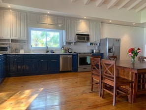 Enjoy cooking in this well-equipped kitchen with a central island, sink, stove, and microwave.