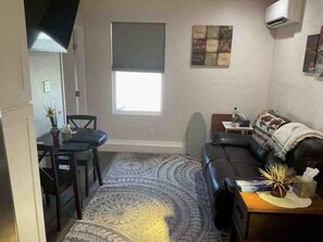 Cozy living space with a sofa, table, and rug, perfect for a small living area or studio apartment.