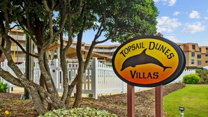Une enseigne pour le complexe hôtelier Topsail Dunes Villas, avec une illustration de dauphin.