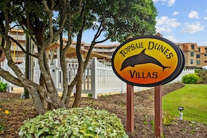 Schild für die Topsail Dunes Villas mit einem Delphin-Grafik.