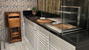 A kitchen with a stainless steel range hood, a wooden cutting board, and a wooden rack. - High standard, beachfront. (Ubatuba)