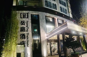 Un moderno edificio de hotel con señalización iluminada, amplias ventanas y una zona de entrada cubierta.