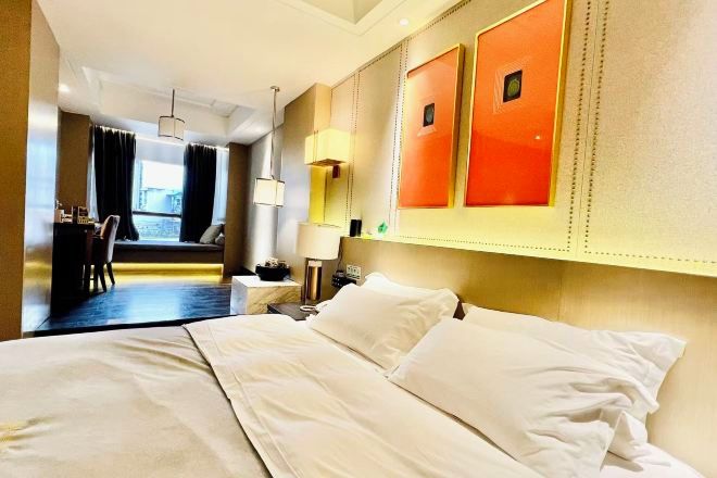 A hotel room with a bed, a desk, and a chair.