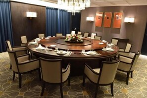 A conference room with a round table, chairs, and a floral centerpiece. - yueTing Chain Hotel (Hanyuan)