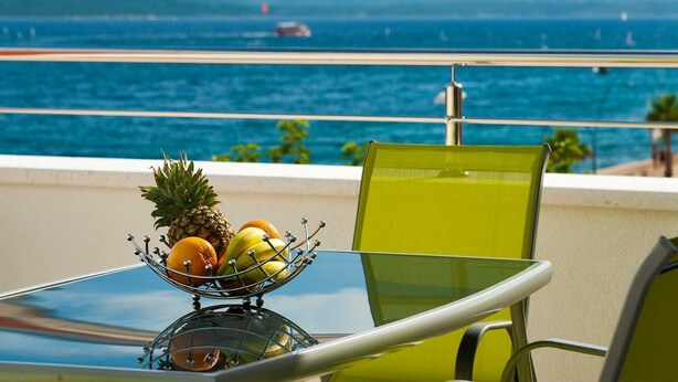 A table with a fruit bowl on a balcony overlooking a body of water with boats. - Luxury Villa Old Story with Pool (Bol)