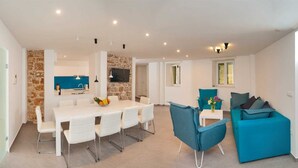 A modern apartment with a dining area, kitchen, and living space. - Luxury Villa Old Story with Pool (Bol)