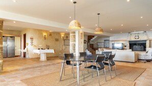 A spacious living area with a dining table, chairs, and a fireplace.