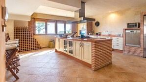 A spacious kitchen with a large island, a built-in oven, and a microwave.