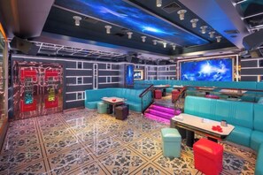 A modern interior with a blue sofa, a staircase, and a large screen. - Shuncheng Hotel (Dongguan)