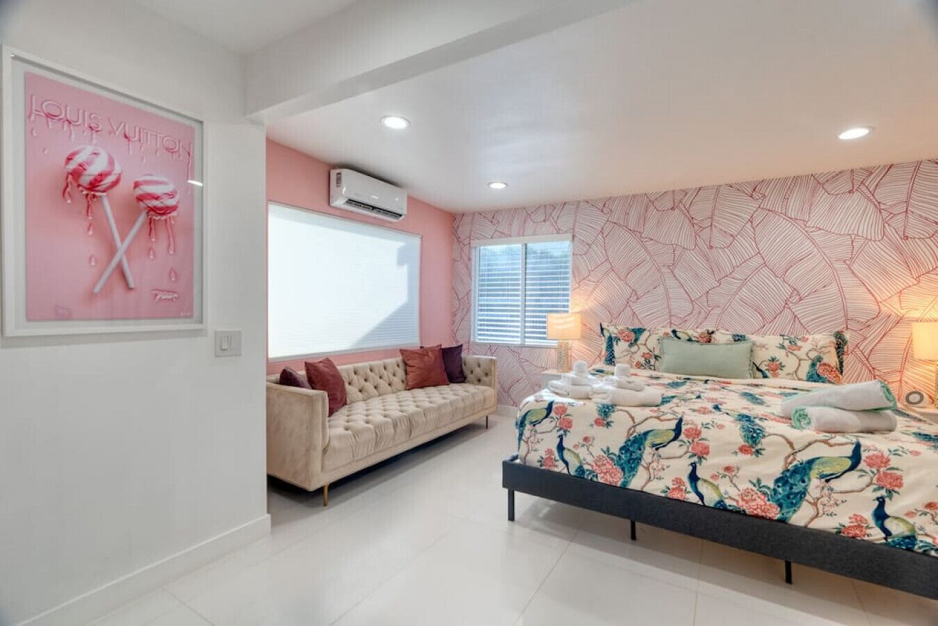 A bedroom with a bed, a sofa, and a window.