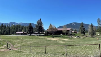 Surrounded by mountains, this property offers a serene escape amidst open fields and trees.
