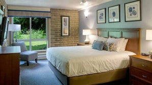 A bedroom with a large bed, a desk, and a chair. There is a window with a view of greenery outside. - Sandstone Creek Club in Vail for Christmas (Vail)
