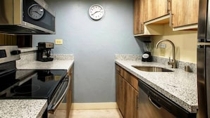 A compact kitchen with a microwave, stove, sink, and a clock on the wall. - Sandstone Creek Club in Vail for Christmas (Vail)