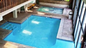 A rectangular indoor swimming pool with a diving board and a small hot tub. - Sandstone Creek Club in Vail for Christmas (Vail)