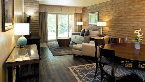 A modern living room with a fireplace, a dining area, and a large window with curtains. - Sandstone Creek Club in Vail for Christmas (Vail)