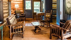 A rustic cabin interior with wooden floors, a ceiling fan, and a large window. - Mountaintop cabin in Pearisburg! (Pearisburg)