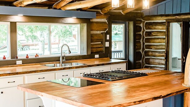 A modern kitchen with a large island, wooden beams, and pendant lighting. - Mountaintop cabin in Pearisburg! (Pearisburg)