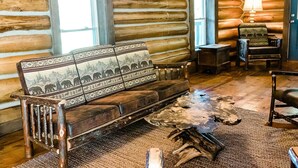 A log cabin interior with a sofa, chairs, a coffee table, and a lamp. - Mountaintop cabin in Pearisburg! (Pearisburg)