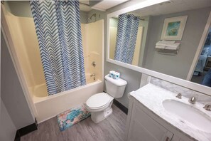 A bathroom with a bathtub, toilet, and sink.