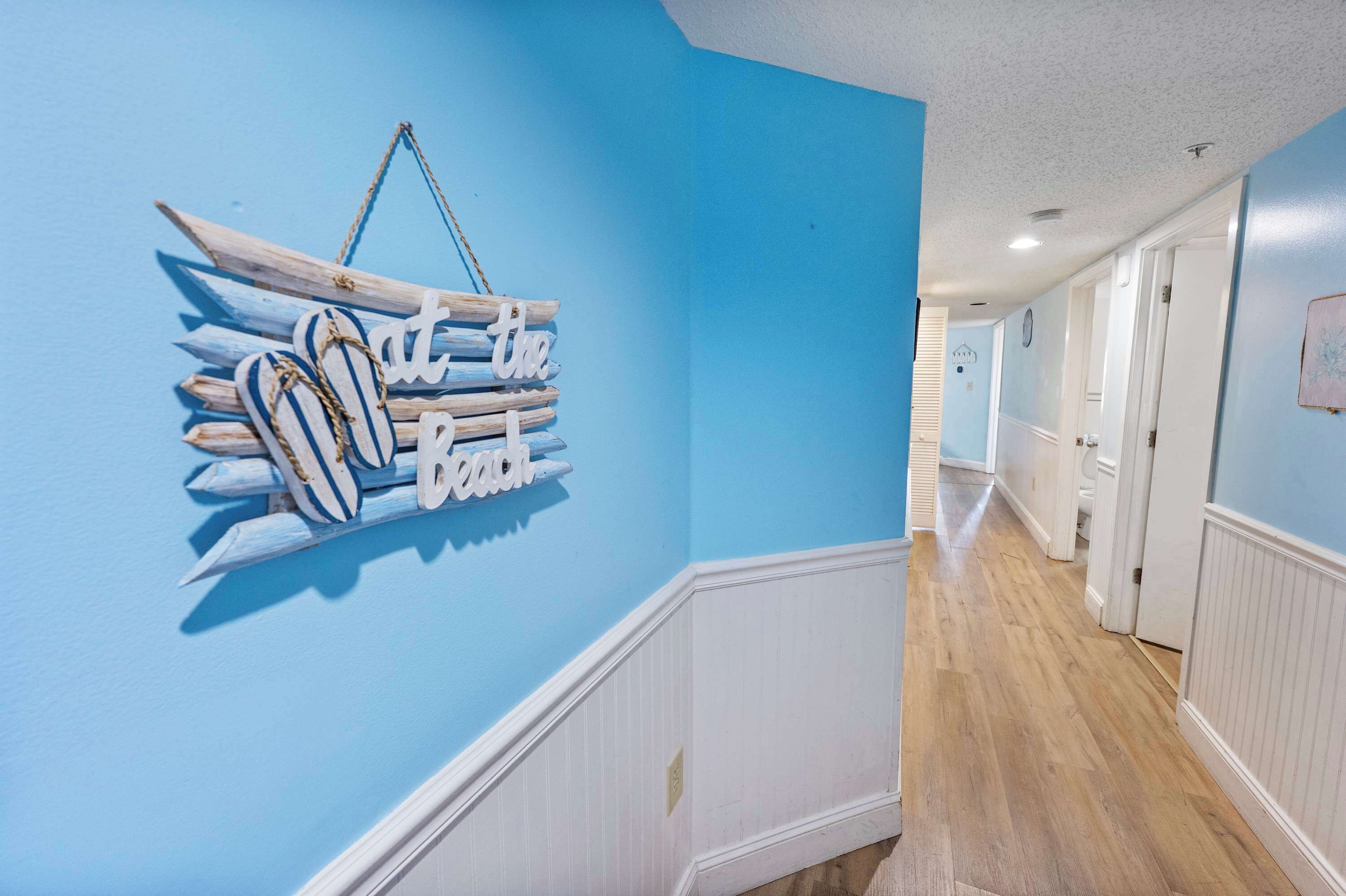 Un pasillo con una pared azul y un letrero de madera.