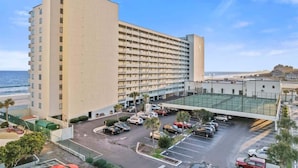 A multi-story hotel with a parking lot and a view of the beach. - New Direct Ocean View, Exclusive Sand Beach Club! (Myrtle Beach)
