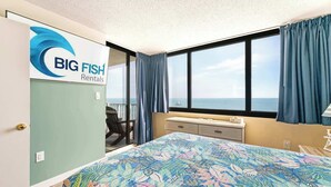 A room with a bed, a window with curtains, a desk, and a chair. - New Direct Ocean View, Exclusive Sand Beach Club! (Myrtle Beach)