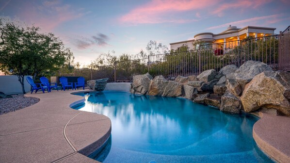 Relax by the serene pool surrounded by lush greenery and tranquil trees.