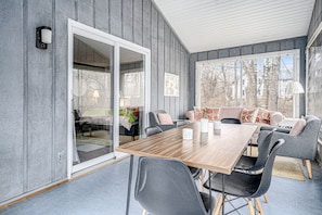 Relax in this spacious room with a dining table, sofa, and sliding door to an outdoor area.