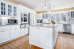 Enjoy cooking in this well-equipped kitchen with stainless steel appliances, a central island, and pendant lighting.