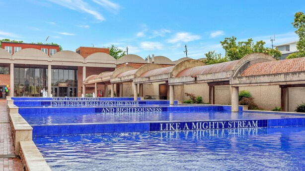 A swimming pool with a blue tiled edge and a sign that reads "We will not be satisfied down like water until justice rolls and righteousness like a mighty stream." - Adorable Atlanta gem near downtown with WiFi, backyard, & excellent location (Atlanta)