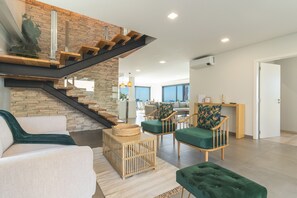 Un intérieur moderne avec un escalier, un coin salon et une vue sur le salon.