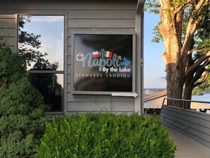 Un cartel que dice 'Napoli by the Lake', con vista al lago y un árbol.