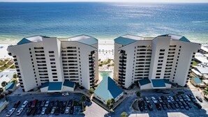 A pair of high-rise buildings with a beach view, parking area, and a clear sky. - Lands' End @ Sunbird :5th floor Sleeps 4 Gulf Front (Panama City)