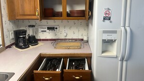 A kitchen with wooden cabinets, a white refrigerator, a coffee maker, a blender, and a dish rack. - Biloxi Shuckers walk to the Blue Wahoos stadium!Close to Navy Base & Beaches. (Pensacola)