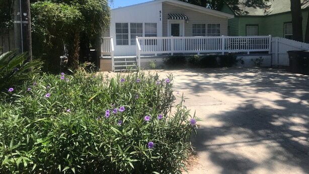 A two-story house with a white exterior, a front porch, and a driveway. - Biloxi Shuckers walk to the Blue Wahoos stadium!Close to Navy Base & Beaches. (Pensacola)