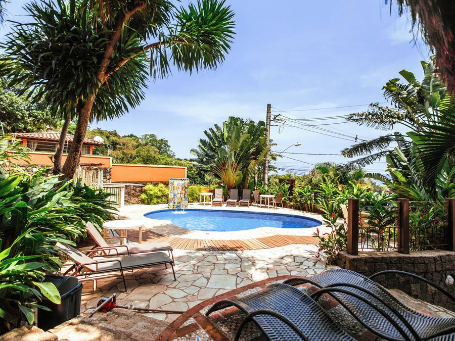 A pool area with lounge chairs, a fire pit, and a stone deck.