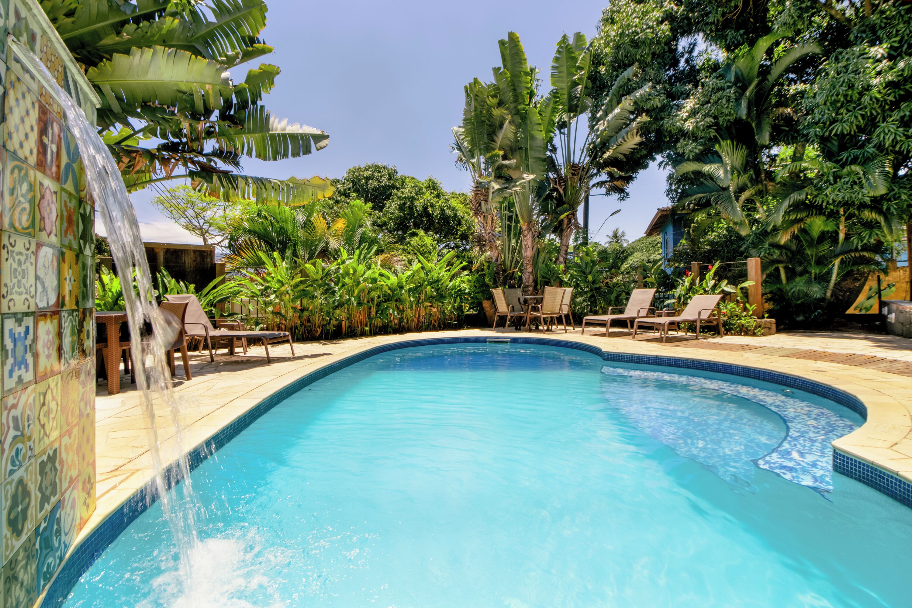 Een buitenzwembad, parasols bij het zwembad en ligstoelen