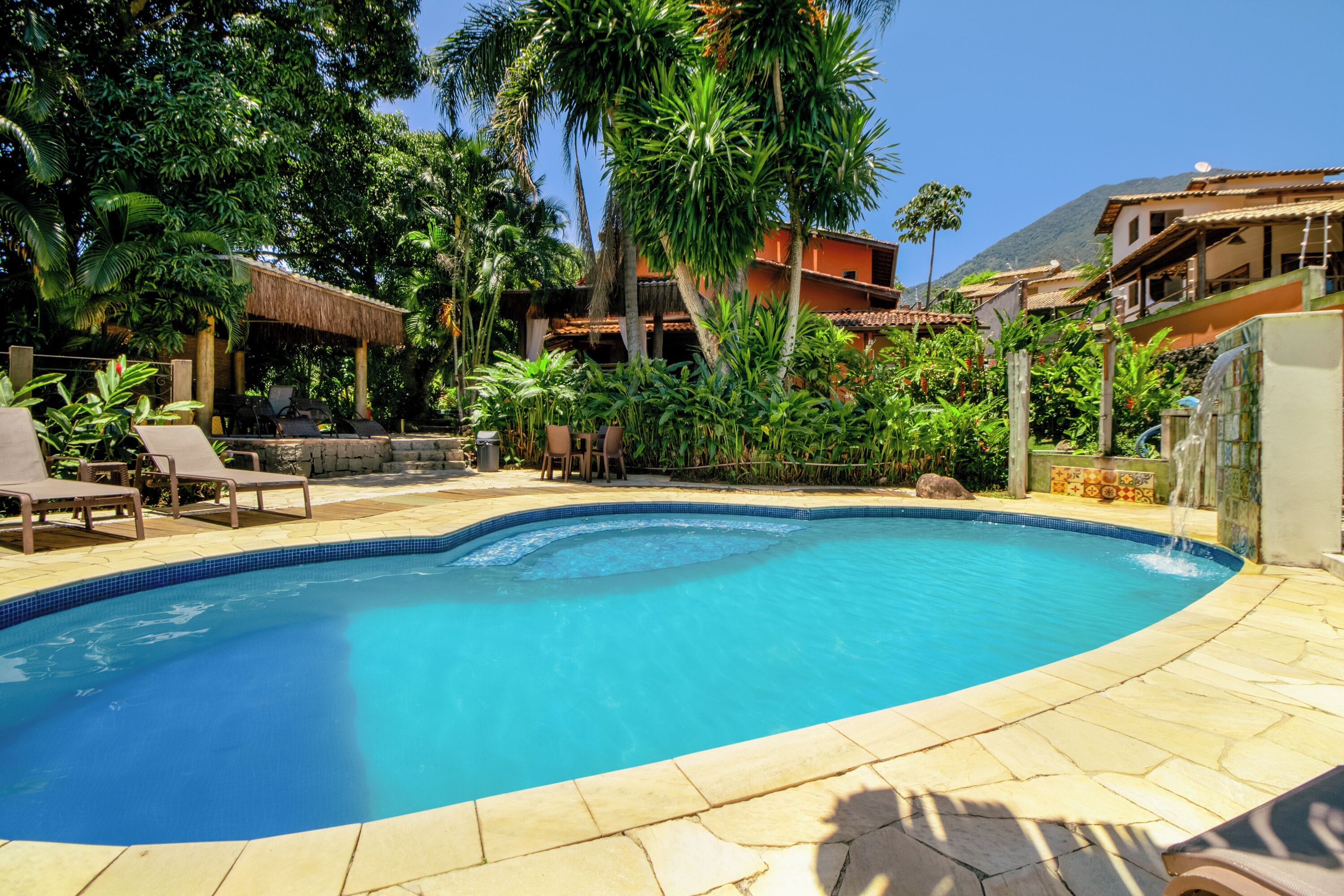 Een buitenzwembad, parasols bij het zwembad en ligstoelen