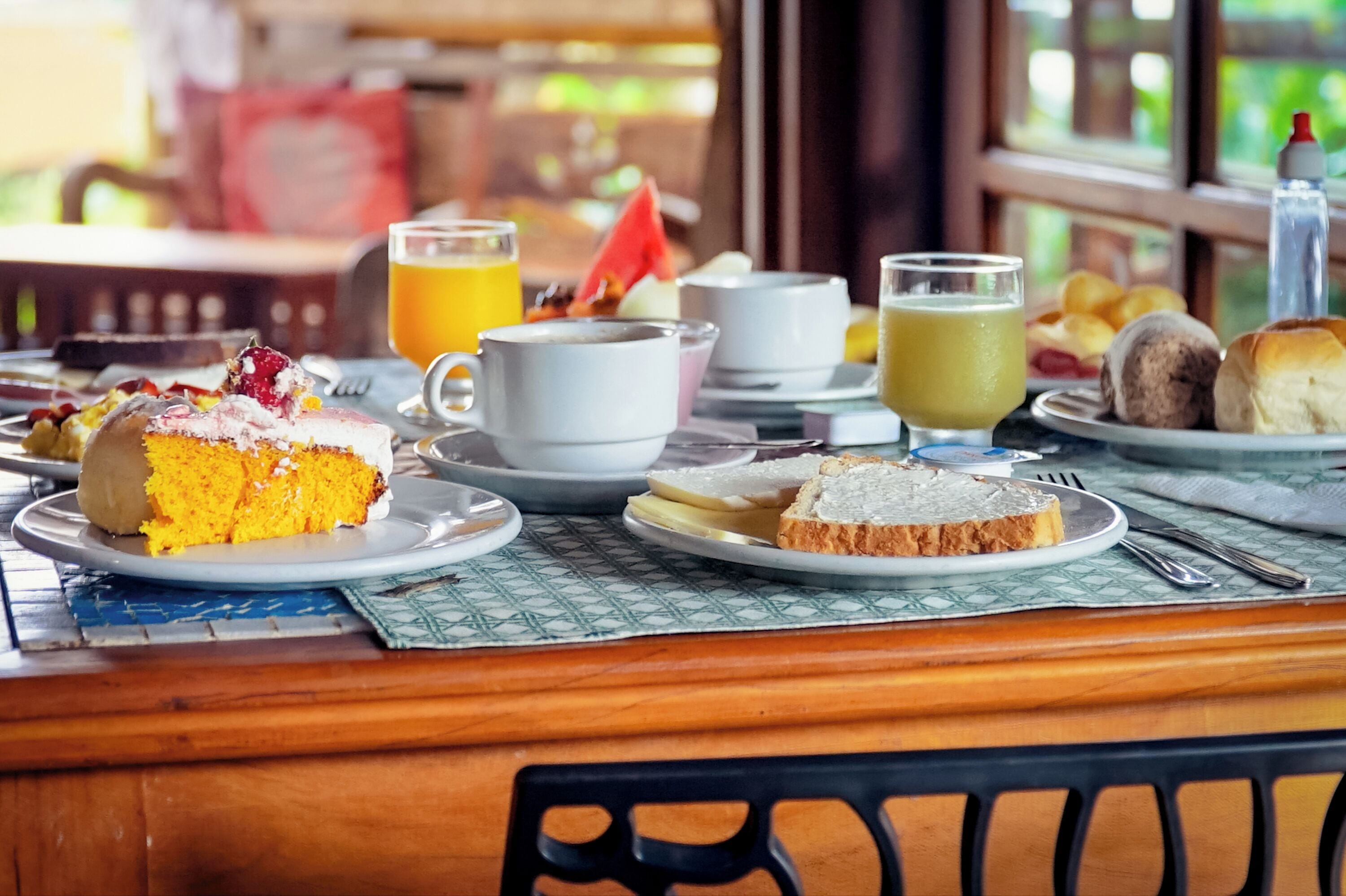 A breakfast table with various food items and beverages.