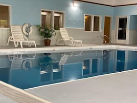 Una piscina techada, sillones reclinables de piscina