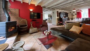 A cozy living room with a fireplace, red walls, and a modern glass coffee table. - SARAHANDIA - ALDUDES (LES-ALDUDES)