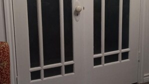 Una puerta blanca con paneles de vidrio y una cerradura.
