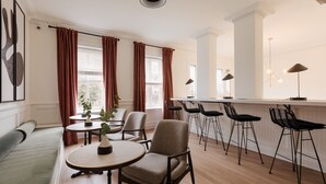 A modern dining area with a bar, seating, and a view of the city. - Dupont Circle Embassy Inn by FOUND (Washington)