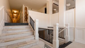 A grand staircase with marble steps and black railings, leading to an upper floor. - Dupont Circle Embassy Inn by FOUND (Washington)