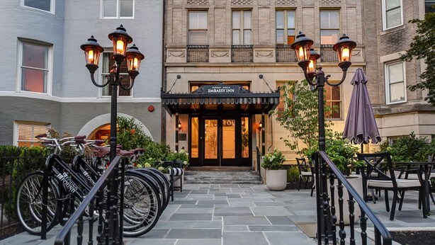 A hotel entrance with a stone-paved walkway, a black railing, and a row of bicycles. - Dupont Circle Embassy Inn by FOUND (Washington)