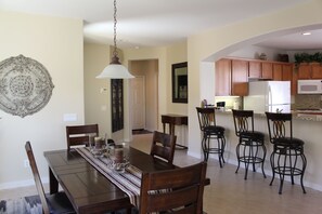 A dining area with a wooden table, chairs, and a decorative wall piece.